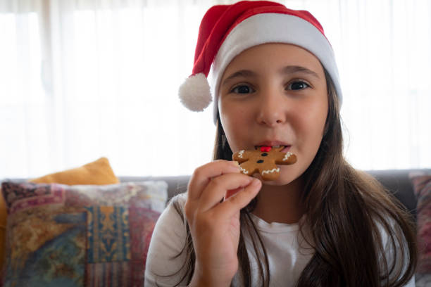 istock Portrait smiling girl eating gingerbread cookie 2175578935