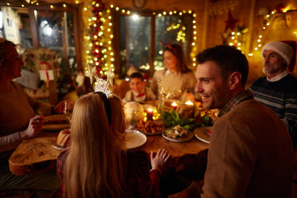 istock Happy father and daughter talking during Christmas dinner at dining table. 2175578978