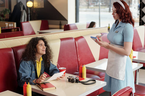istock Smiling Young Man Interacting with Waitress in Diner 2175579257