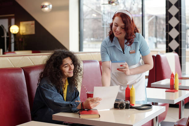 istock Smiling Waitress Taking Order from Customer in Diner 2175579258
