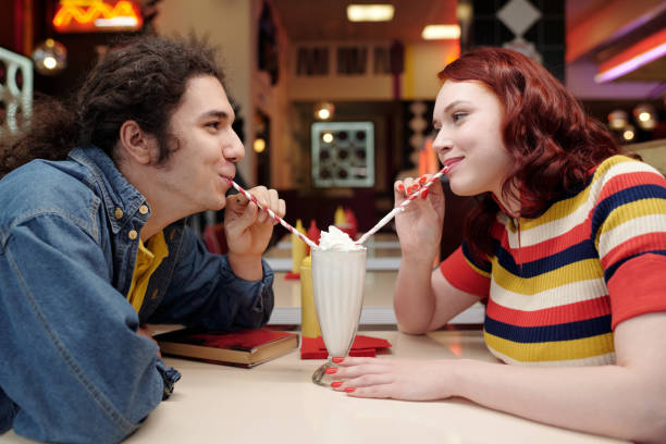 istock Sharing Milkshake in Retro Diner with Joyful Smiles 2175579280