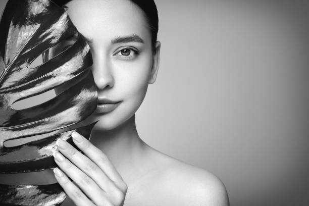 istock Close up woman face with green exotic leaf 2175584896