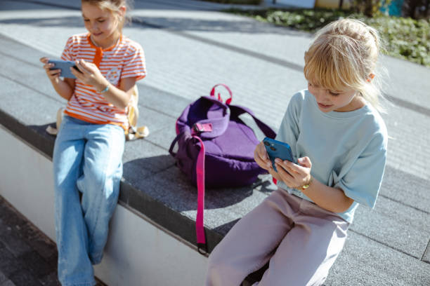 istock Kids using smartphones outdoors 2175585409