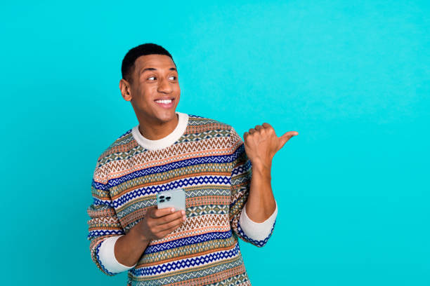 istock Portrait of nice young man hold phone point finger empty space wear pullover isolated on turquoise color background 2175586176