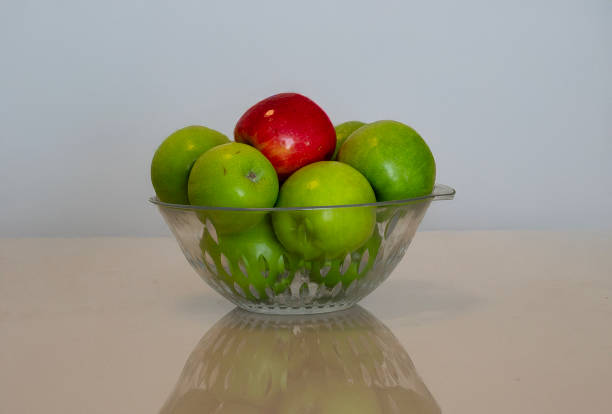 Red and green apples arranged close-up on a wooden table, showcasing their vibrant colors and fresh textures, perfect for highlighting the natural beauty of the fruit.