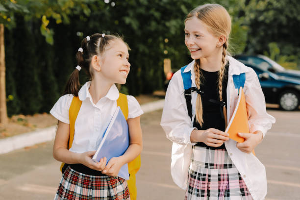 istock Two happy pupils walking together holding notebooks and smiling 2175589545