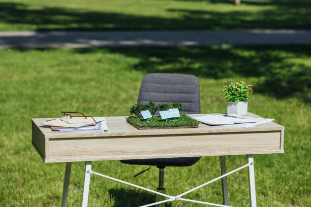 3d render of fallen chair and wooden desk outside in grassy field