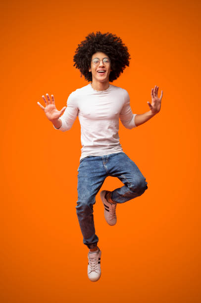 istock Cheerful african-american curly guy jumping in air 2175597235