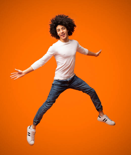 istock Cheerful african-american curly guy jumping in air 2175597244