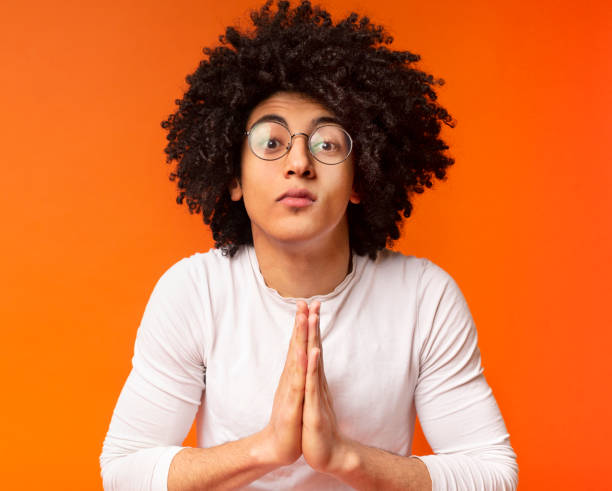 istock Young black man showing clasped hands in pleading gesture 2175597278