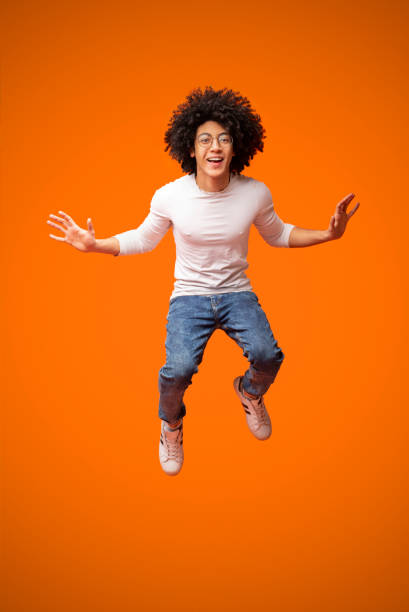 istock Cheerful african-american curly guy jumping in air 2175597284