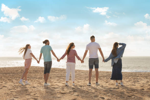 istock Friends holding hands on the beach during a sunny day at the shore 2175607013