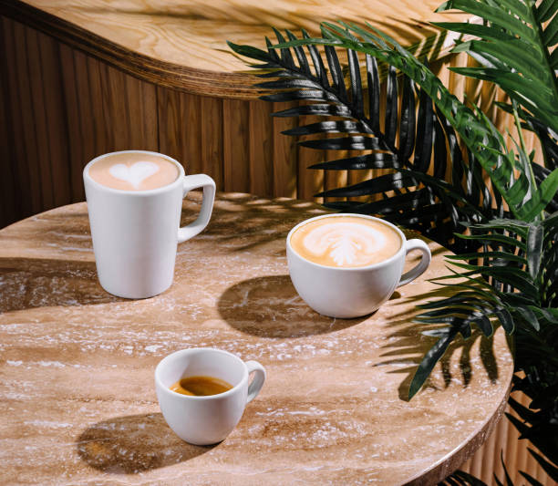 istock Three cups of coffee sitting on a table with a palm tree in the background 2175607346