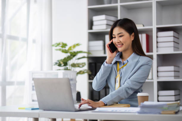 istock Professional Female Accountant Using Phone to Contact Customer in Modern Office Setting 2175608765