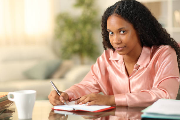istock Black tele worker writing in agenda looking at you 2175608882