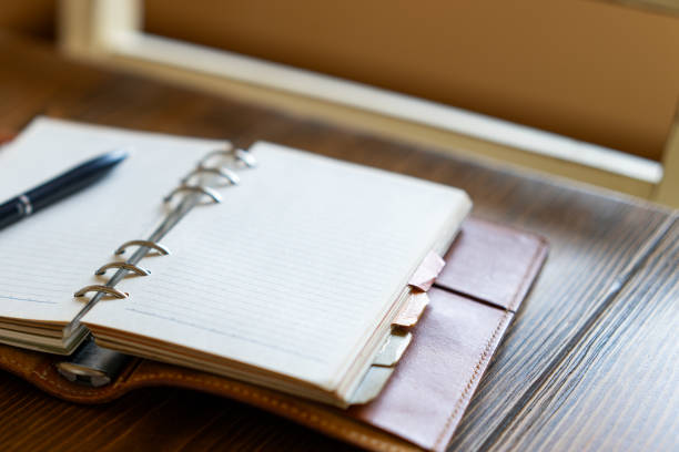 Ring bound planner and pen on wooden table