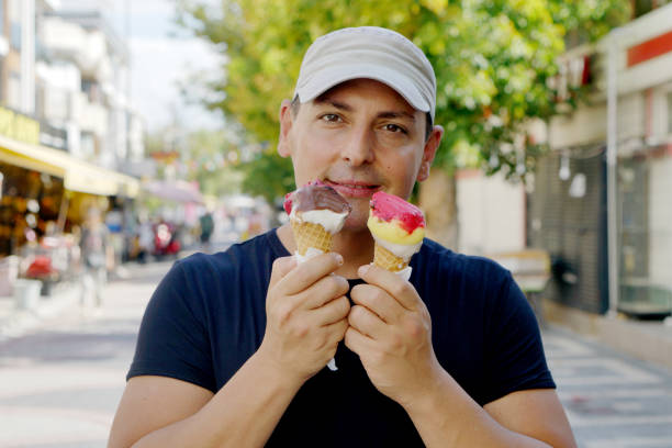 Handsome Young Boy Eating Ice Cream From Two Cones