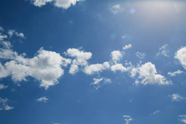 istock White cumulus clouds float across the blue sky. 2175625381