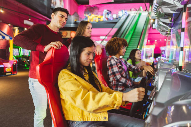 istock Friends Focused on Arcade Racing Game in Colorful Arcade 2175626647
