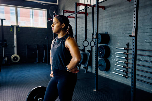 istock Taking a break in between reps. Strong female athlete strength training in a gym. 2175627932
