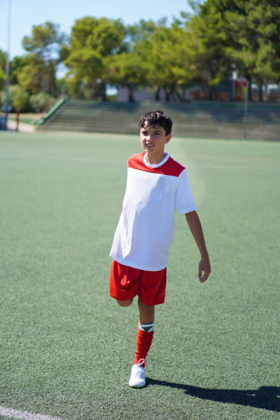 preteen boy stretching and warming up before playing a soccer game