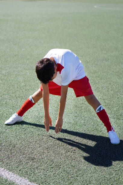 istock preteen boy stretching and warming up before playing a soccer game 2175634488