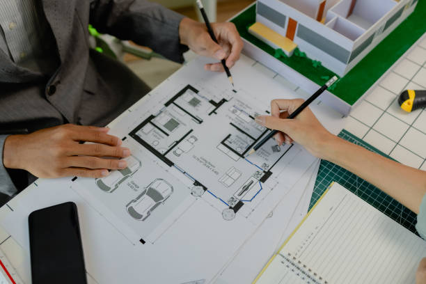 istock engineers are sitting discussing a construction plan that needs to be revised to make the structure stronger, an architect and assistant are brainstorming and examining the blueprints 2175637913