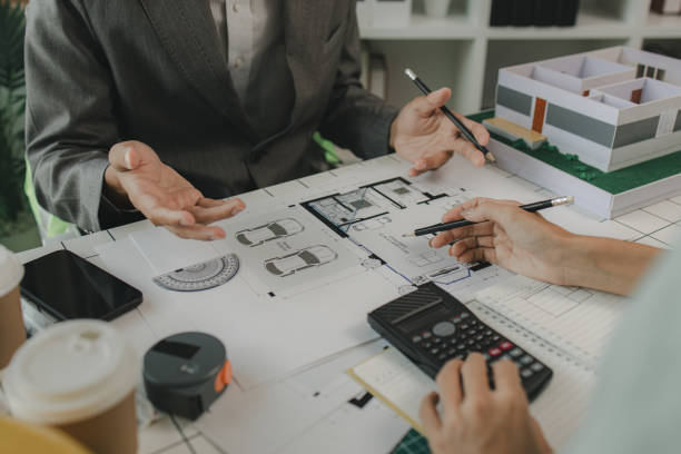 istock an architect and his assistant are brainstorming and examining the blueprints, two engineers are discussing a construction plan to make the structure stronger, draft, meeting, teamwork 2175637917