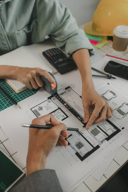 istock engineers are sitting discussing a construction plan that needs to be revised to make the structure stronger, an architect and assistant are brainstorming and examining the blueprints 2175637957