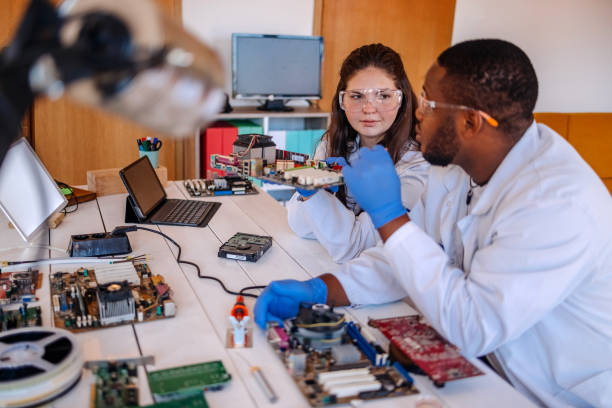 istock University students working together on project at home using electronic parts for making a computer and asking for support using mobile phone 2175639620
