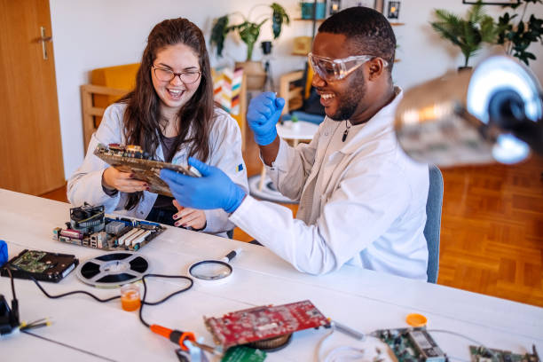 istock University students working together on project at home using electronic parts for computer build and happy for their success 2175640466