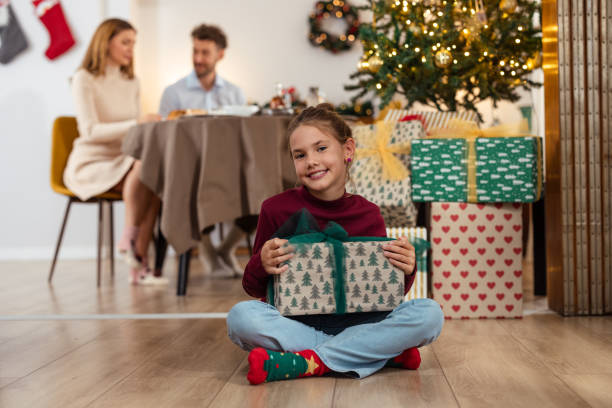 istock A young girl holding a present and spreading Christmas cheer 2175640516