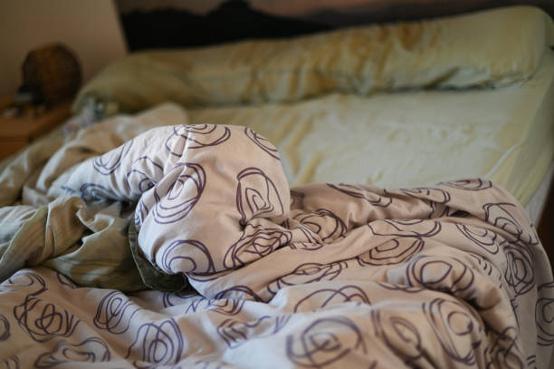 unmade bed with the duvet loosely draped over