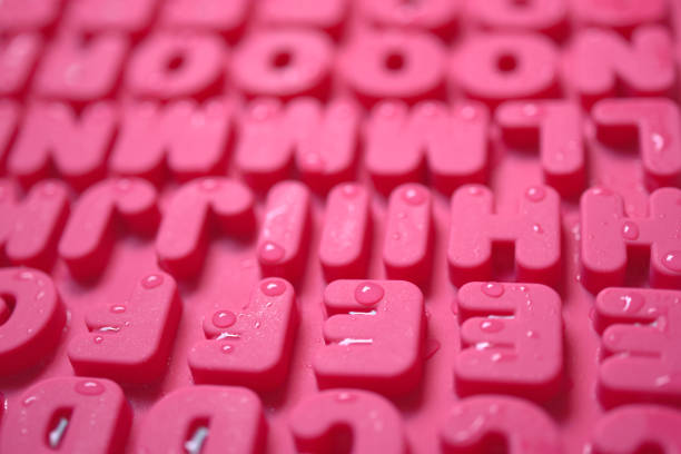 Scattered cubed beads of alphabet letters against white