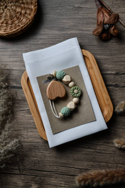 istock Handmade Heart Shaped Chain Accessory for Baby's Pacifier on Wooden Background 2175649445