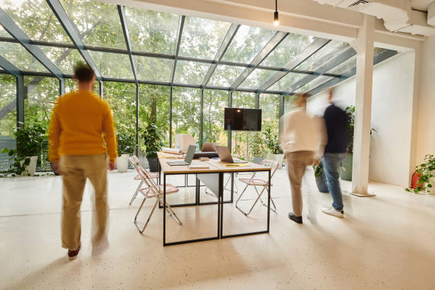 istock Three professionals walk together in a lively workspace filled with plants and natural light 2175651799