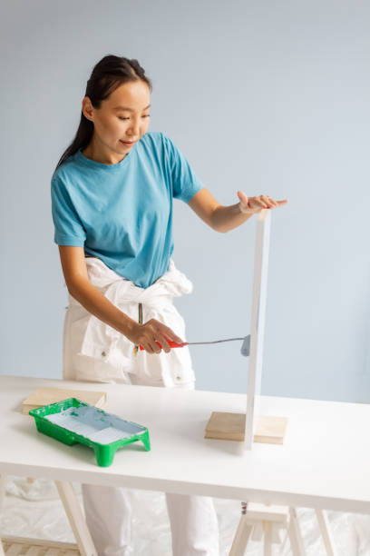 istock Focused woman painting board in creative workspace setting 2175651876