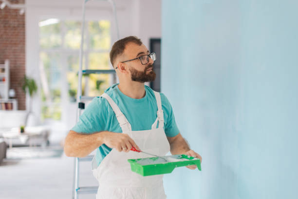 istock Intense painting session on blue wall by painter 2175653660