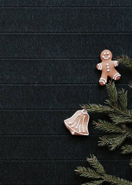 istock Gingerbread and Christmas tree branches on a dark paper craft background. Happy New Year Banner 2175654465