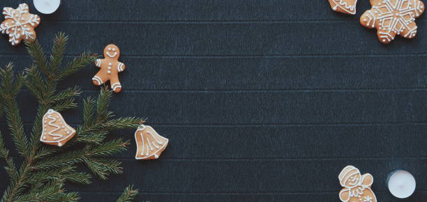 istock Gingerbread and Christmas tree branches on a dark paper craft background. Happy New Year Banner 2175654501