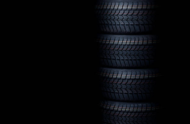Stack of New Winter Tires on Black Background. High-Quality Rubber with Enhanced Tread for Snow and Ice Grip. Great for Sales and Promotions about Preparing Car for Winter Driving.