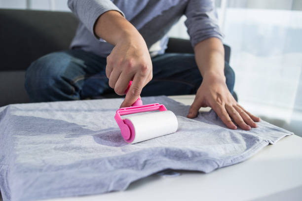 istock Adhesive Roller For Cleaning Cloth On a T-shirt. Lint Roller With Pink Handle. 2175656035