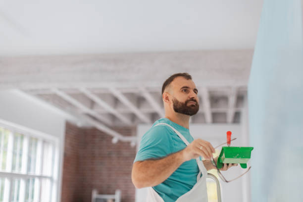 istock Man painting interior wall with blue paint roller. 2175658653
