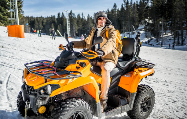 istock Young smiling man on a quad bike on a snowy mountain 2175658914