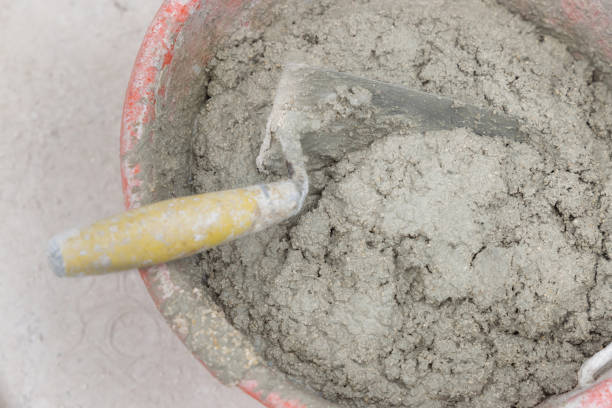 istock Bucket with cement or plaster with two trowels inside, both covered in cement residue, top view 2175659883