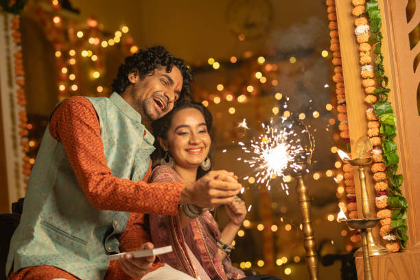 istock Cheerful young couple burning sparklers at home during Diwali 2175661137