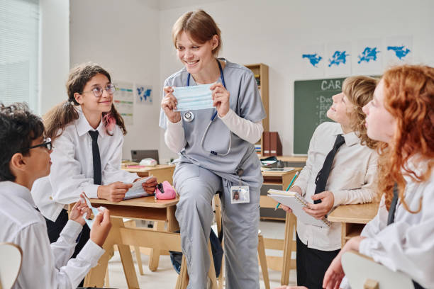 istock Female Nurse Showing Kids How To Use Protective Mask 2175661832