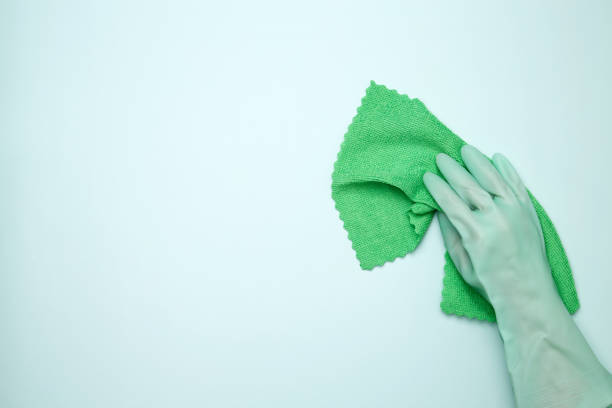 istock Womans hand in rubber glove holds cloths. House cleaning. Copy space 2175664012