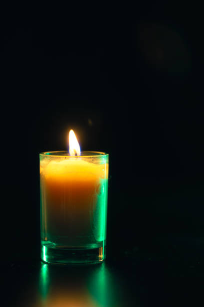istock Burning candle on black background with backlight. Memorial Day. 2175664352