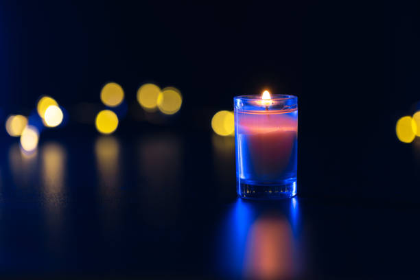 Burning candle on black background with bokeh. Memorial Day. High quality photo